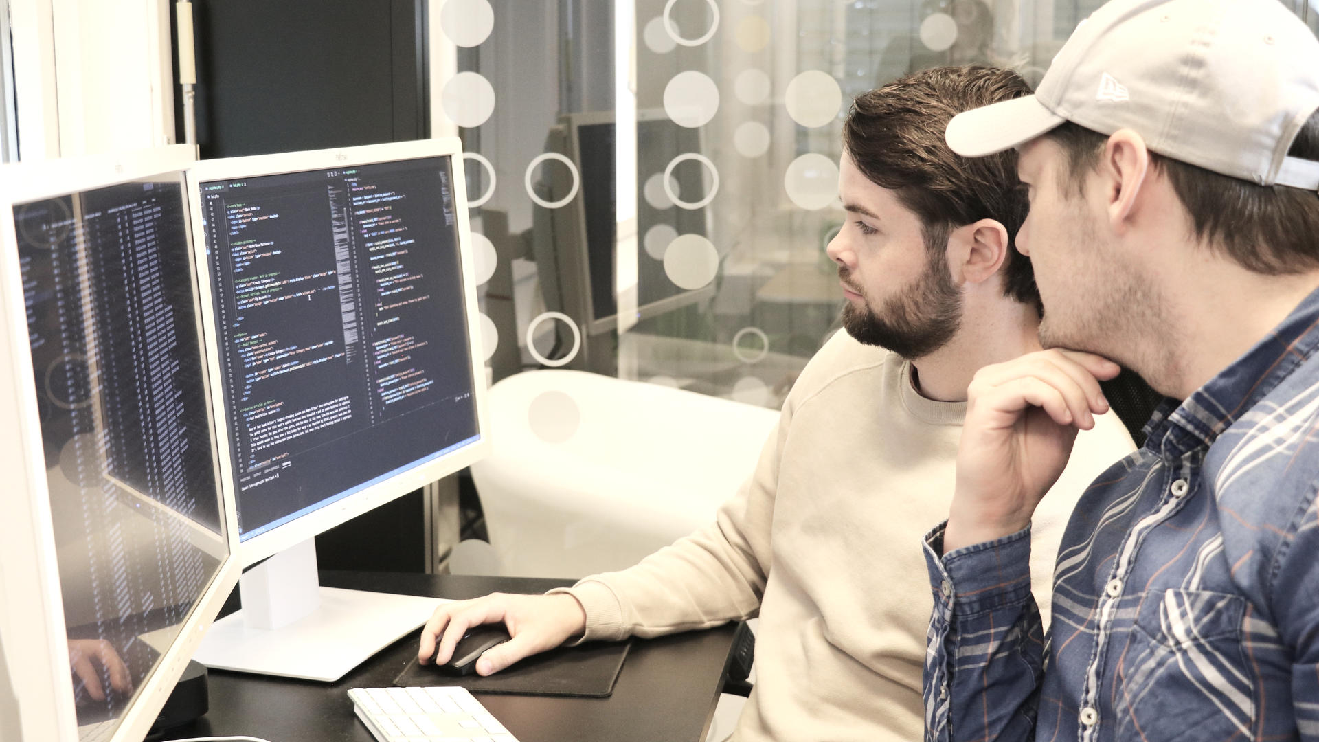 to utviklere foran en PC skjerm